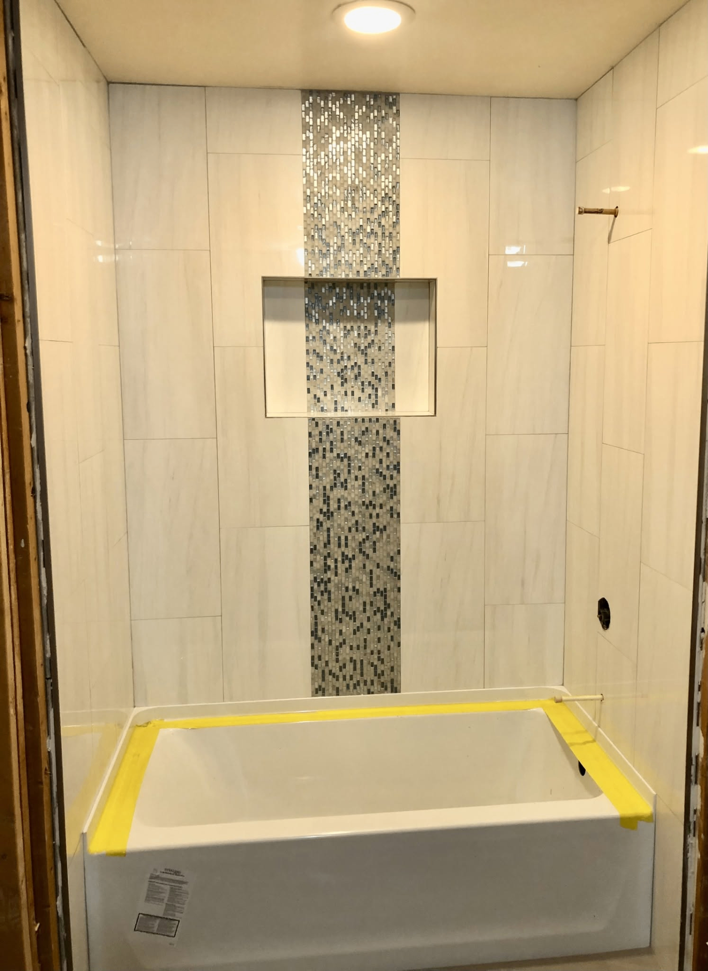 Tub surround with mosaic accent stripe and recessed niche