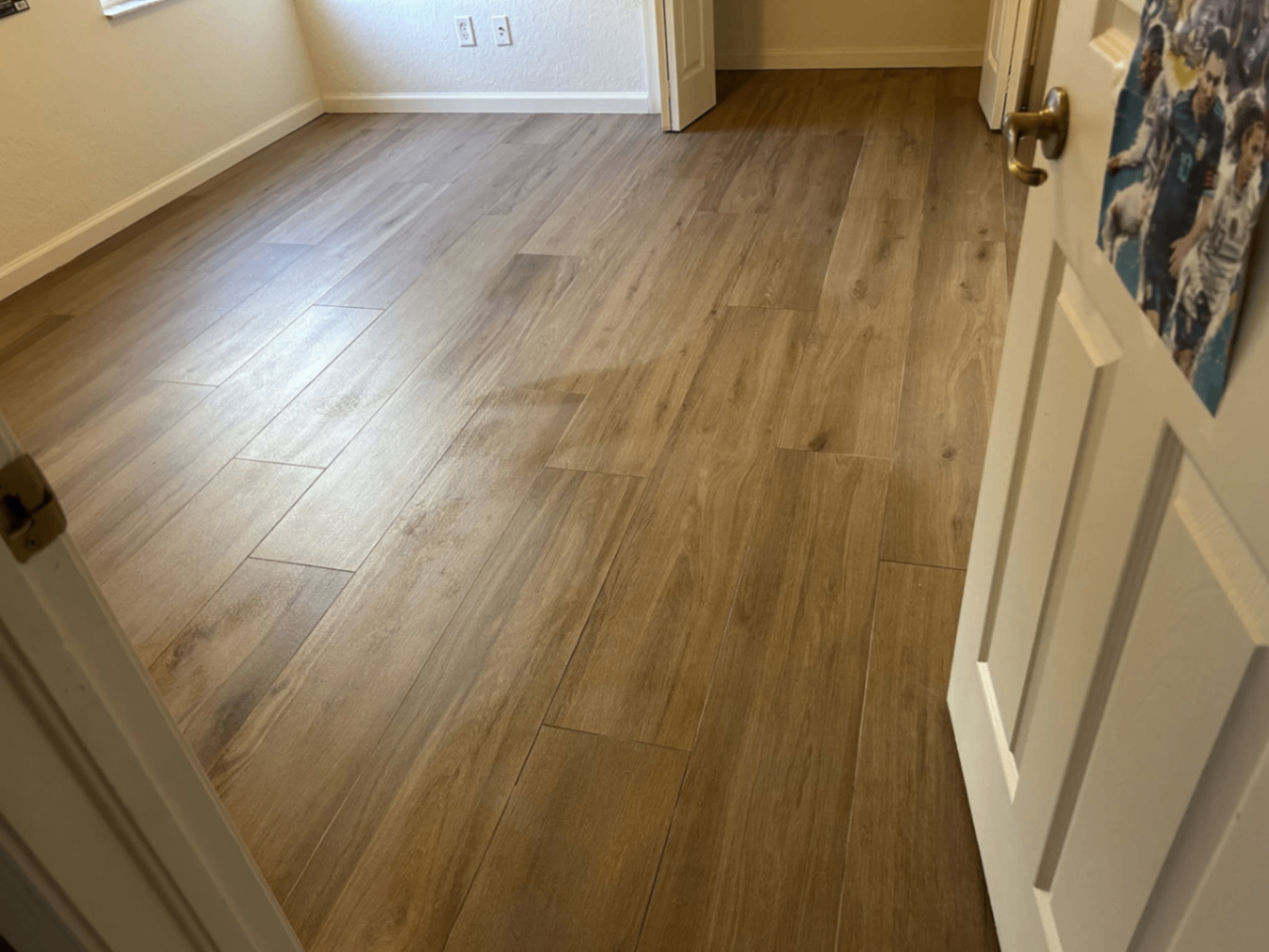 Warm oak wood-look plank tile flooring in a bedroom