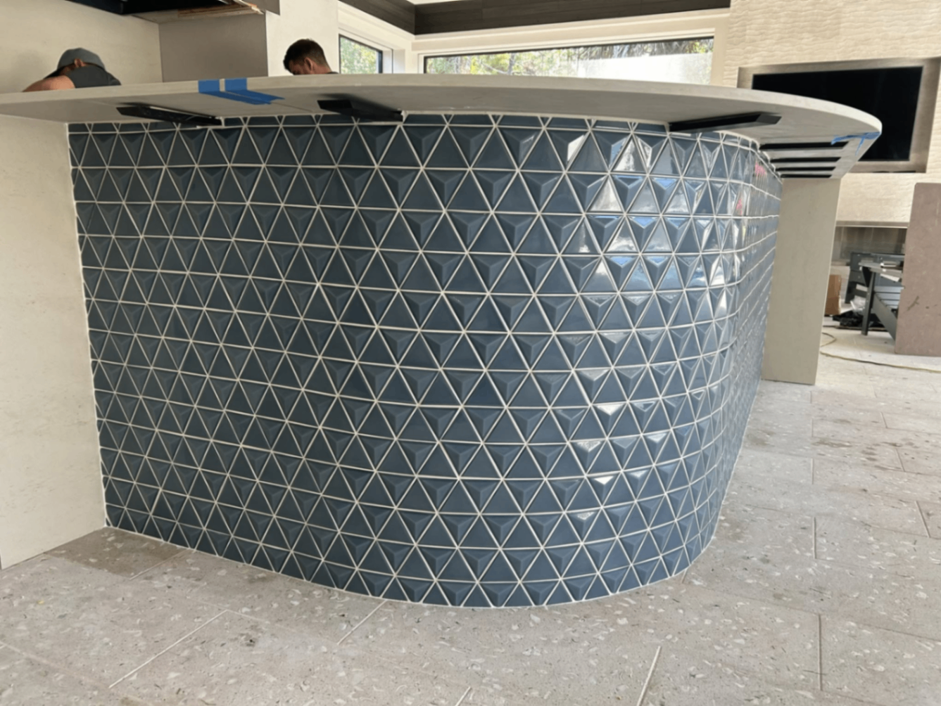 Curved bar face finished with dimensional blue triangle tile