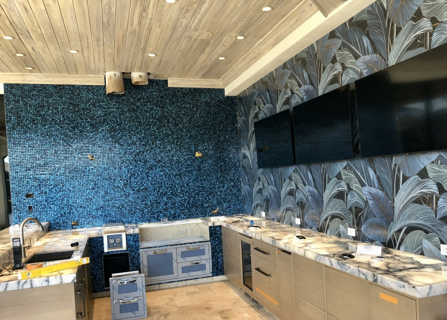 Outdoor kitchen with blue glass mosaic tile backsplash