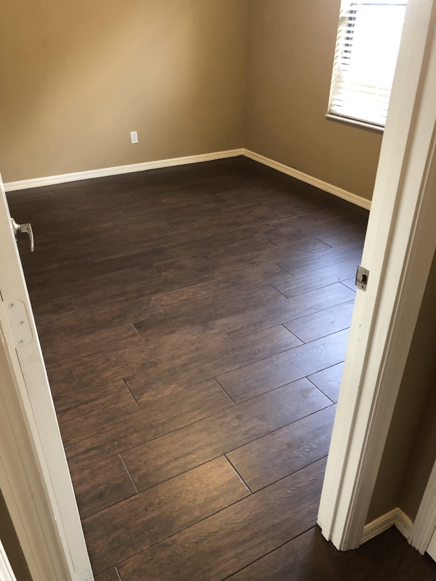 Wood-look plank tile flooring installation in bedroom