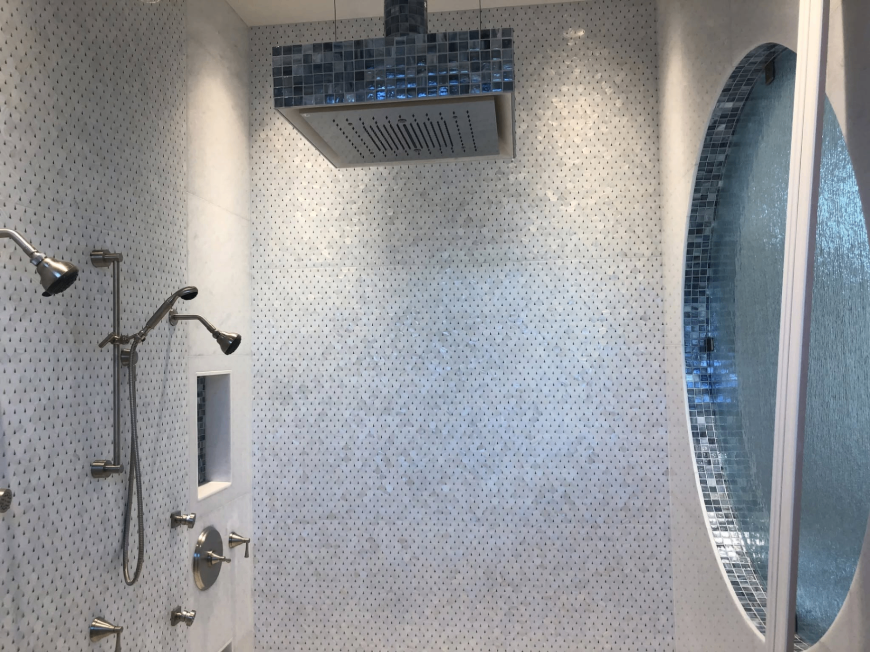 Rain shower with mosaic surround and oval window