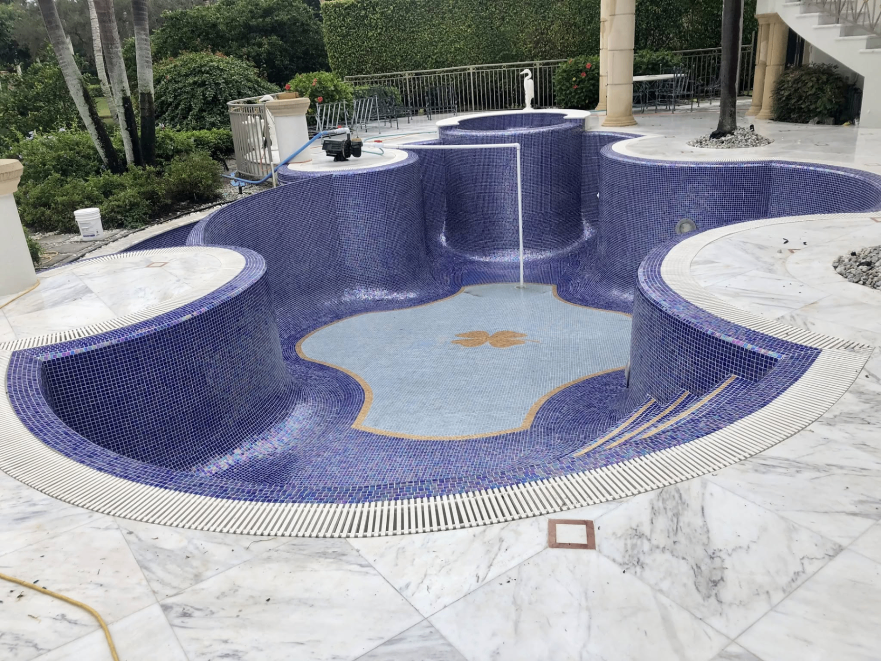 Dark porcelain shower with pebble floor and built-in bench