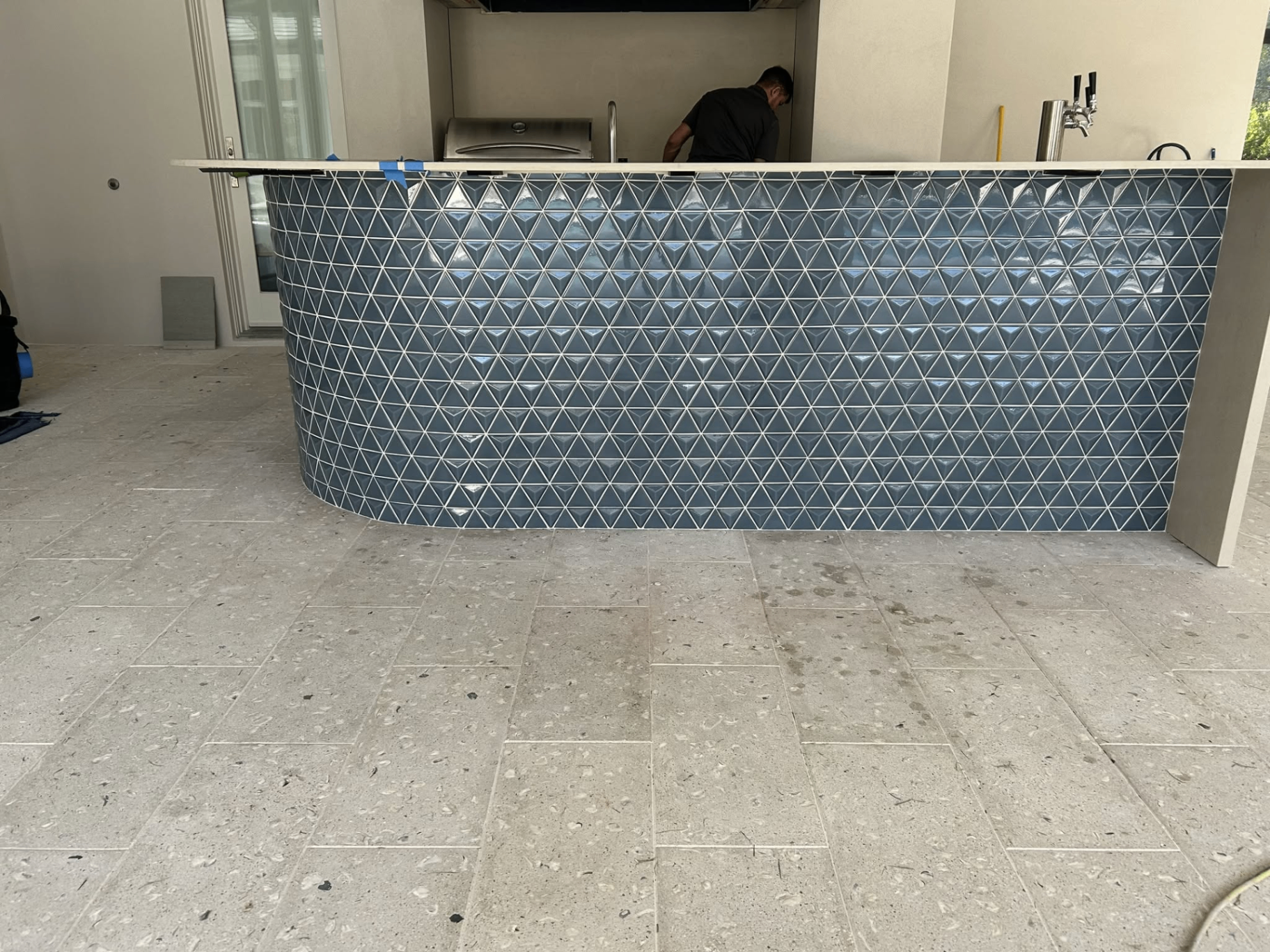 Outdoor bar with blue dimensional triangle tile and travertine floor